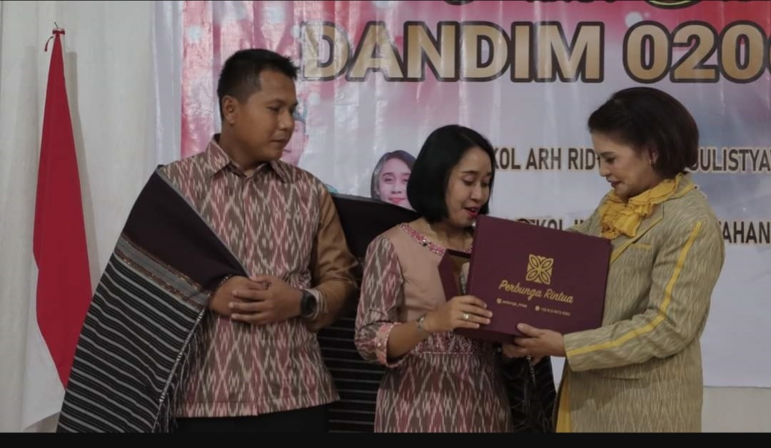 Ny Romy Mariani Simarmata memberikan cendera mata berupa ulos asli tenun Silahisabungan ke Letkol Inf Ridwan Sulystyawan bersama istri