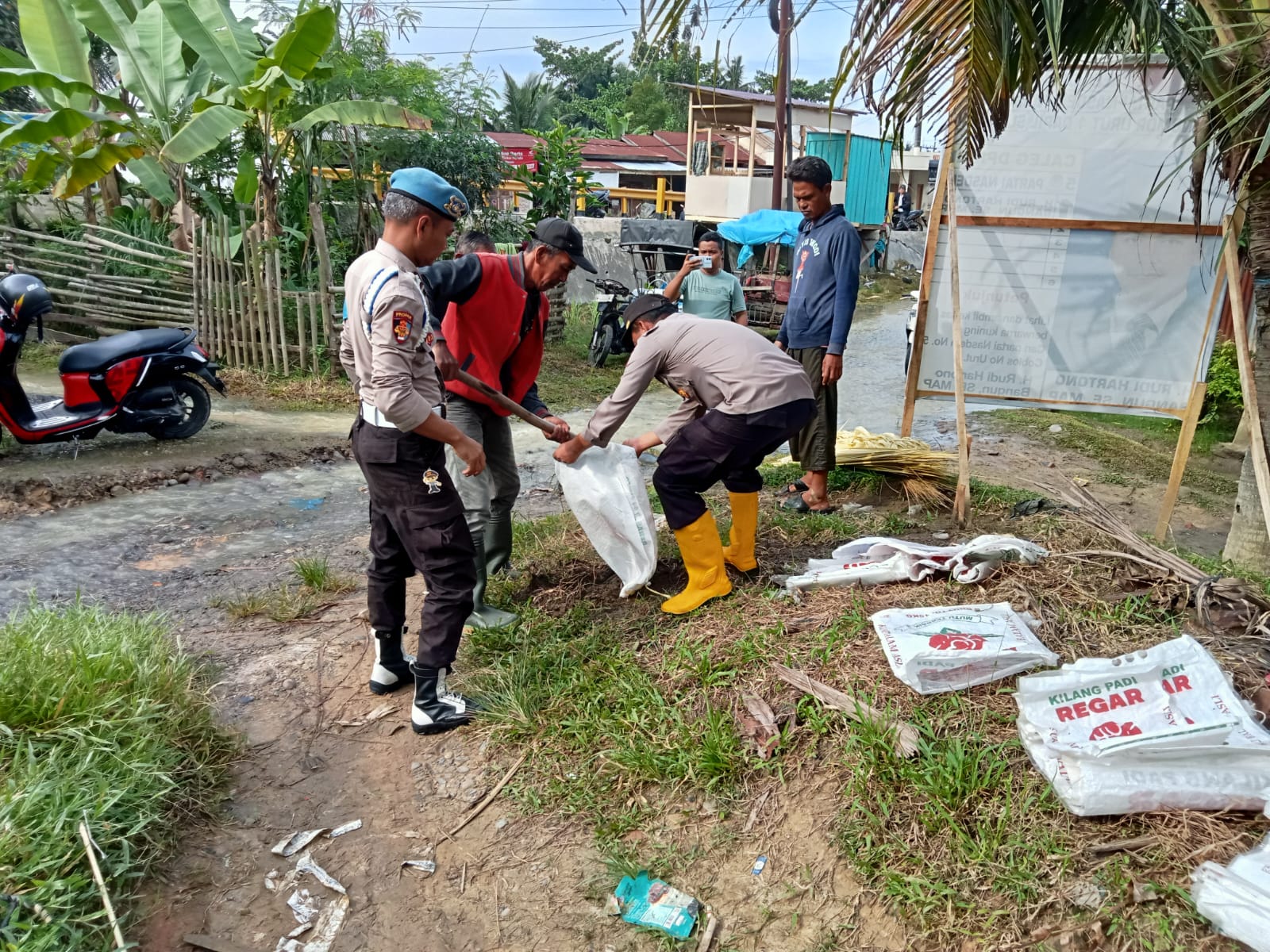 Antisipasi Banjir Meluas Kepemukiman Warga, Polres Langkat Polsek Tanjung Pura Bantu Warga Membuat Tanggul