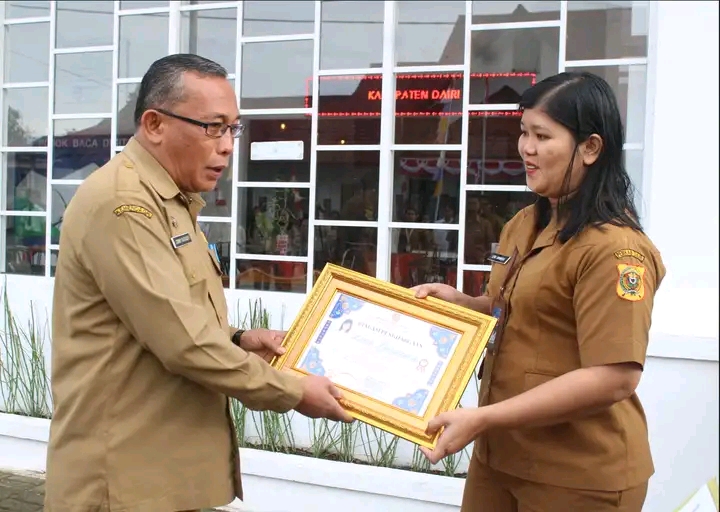PJ. Sekda Dairi Serahkan Piagam Penghargaan Pegawai Terbaik Dinas Dukcapil Dairi